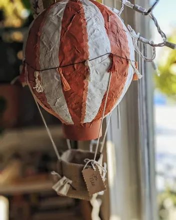 A red-and-white striped hot air balloon hanging in a window