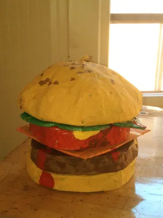 A giant cheeseburger on a table
