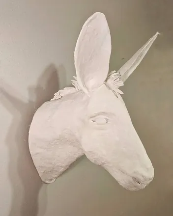 A white donkey head mounted on a wall