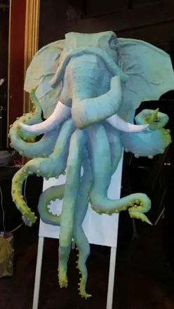The elephant-octopus painted pale blue, on a stand