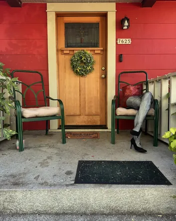 The fishnet legs on a chair by a red front door