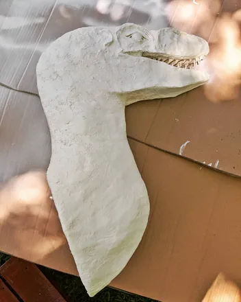 The raptor head beside a window, jaws open