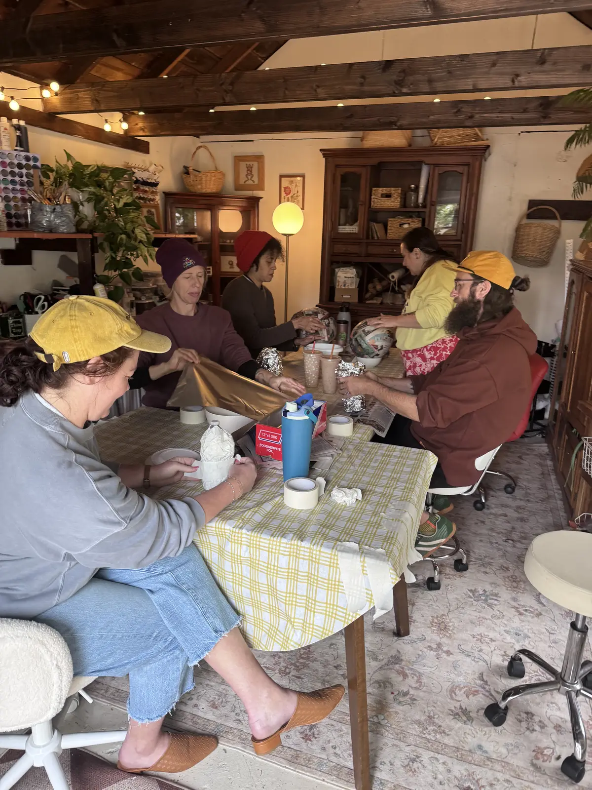 Six people around the long studio table, a class in progress